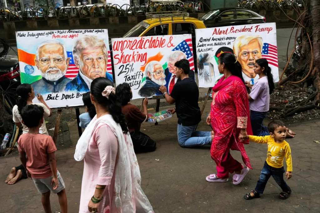People walk by as students of Gurukul school of Art complete artwork of US President Donald Trump and Prime Minister of India Narendra Modi, in Mumbai, India, Friday, Aug. 1, 2025. (Photo by AP)